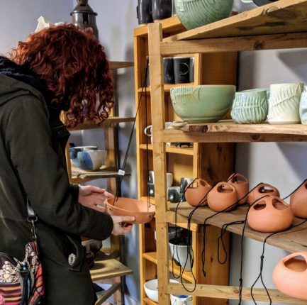 A woman looking at ceramics in a store.