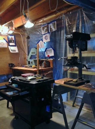 A table with a drill and a drill press.