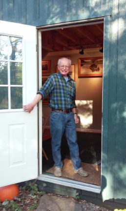 A man standing in the doorway of a shed.