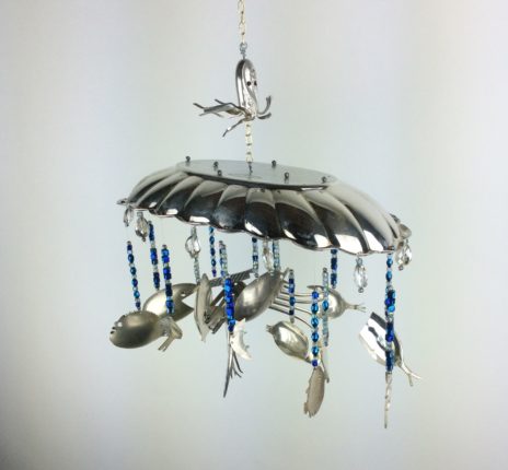A wind chime with fish and spoons hanging from it.