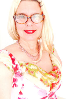 A woman wearing glasses and a floral dress.