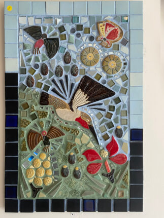 A mosaic panel with birds and flowers on it.