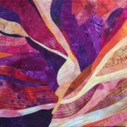 A quilted piece with purple and orange colors.
