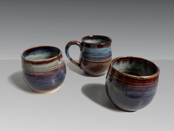 Three mugs on a gray surface.