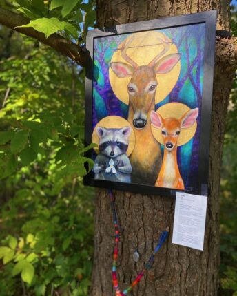 A painting of a deer and a fawn hanging on a tree.