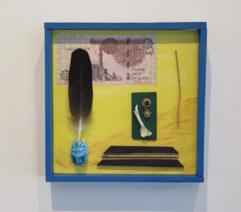 A blue frame with a feather and money on it.