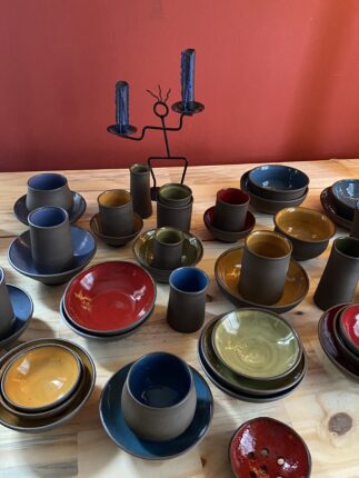 A table full of plates and bowls on a wooden table.