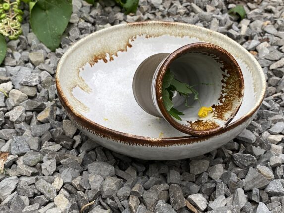 A white bowl with a yellow flower on it.