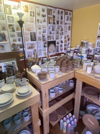 A pottery studio with a lot of plates and bowls.