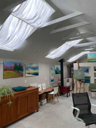 An art studio with a skylight and a chair.
