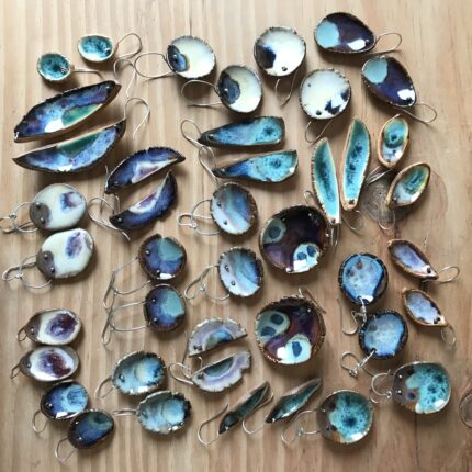 A group of blue and white earrings on a wooden table.