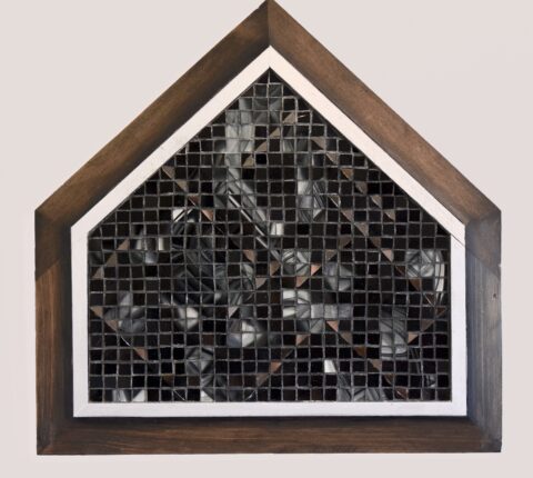 A wooden frame with a black and white mosaic on it.