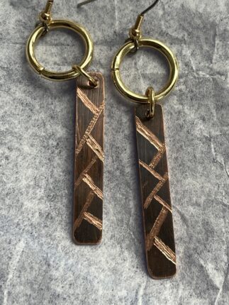 A pair of copper key chains with gold accents.