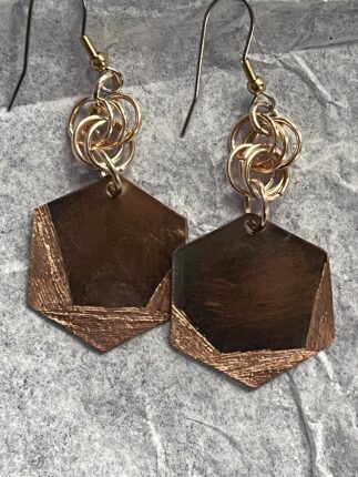 A pair of earrings with gold and copper accents.