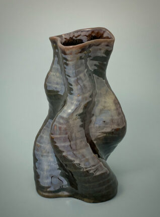 A vase that is made of clay and has been shaped to look like a body.