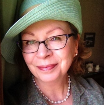 A woman wearing glasses and a green hat.