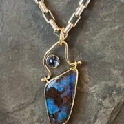 A necklace with a blue opal stone and a blue sapphire.