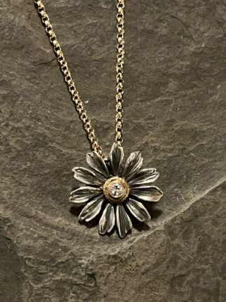 A daisy necklace with a diamond in the center.