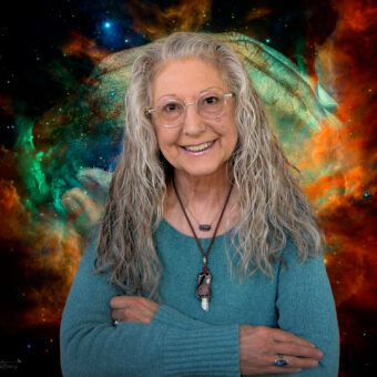 A woman with long hair and glasses standing in front of a space background.