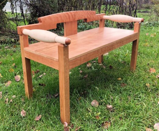 A wooden bench sitting in the grass near some trees.