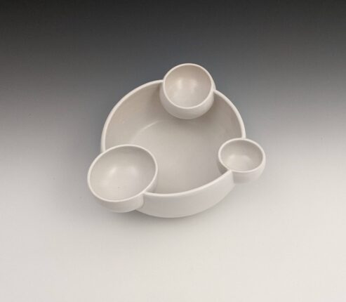 A white bowl with three small bowls in it.