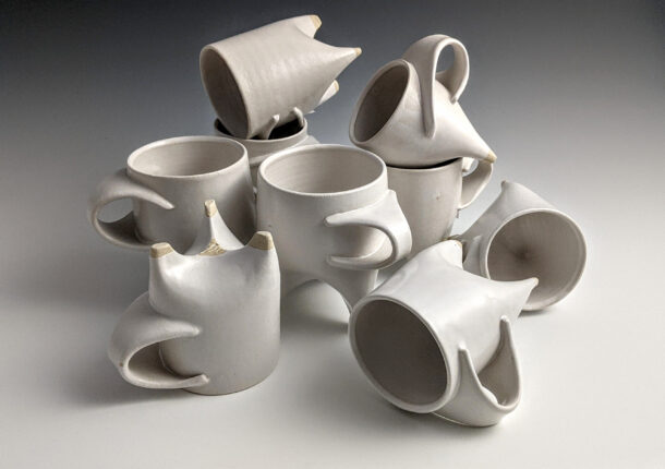 A group of white ceramic mugs arranged in a circle.